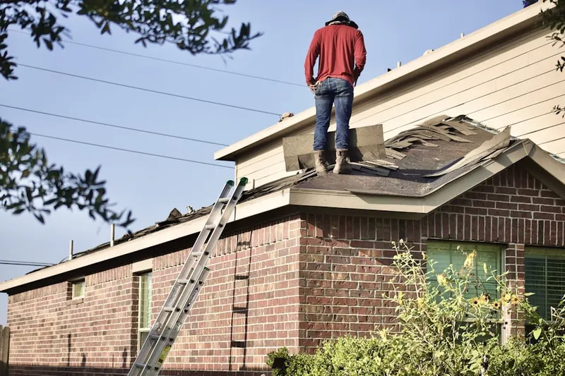 Professional roofer working on a residential roof in Guilderland